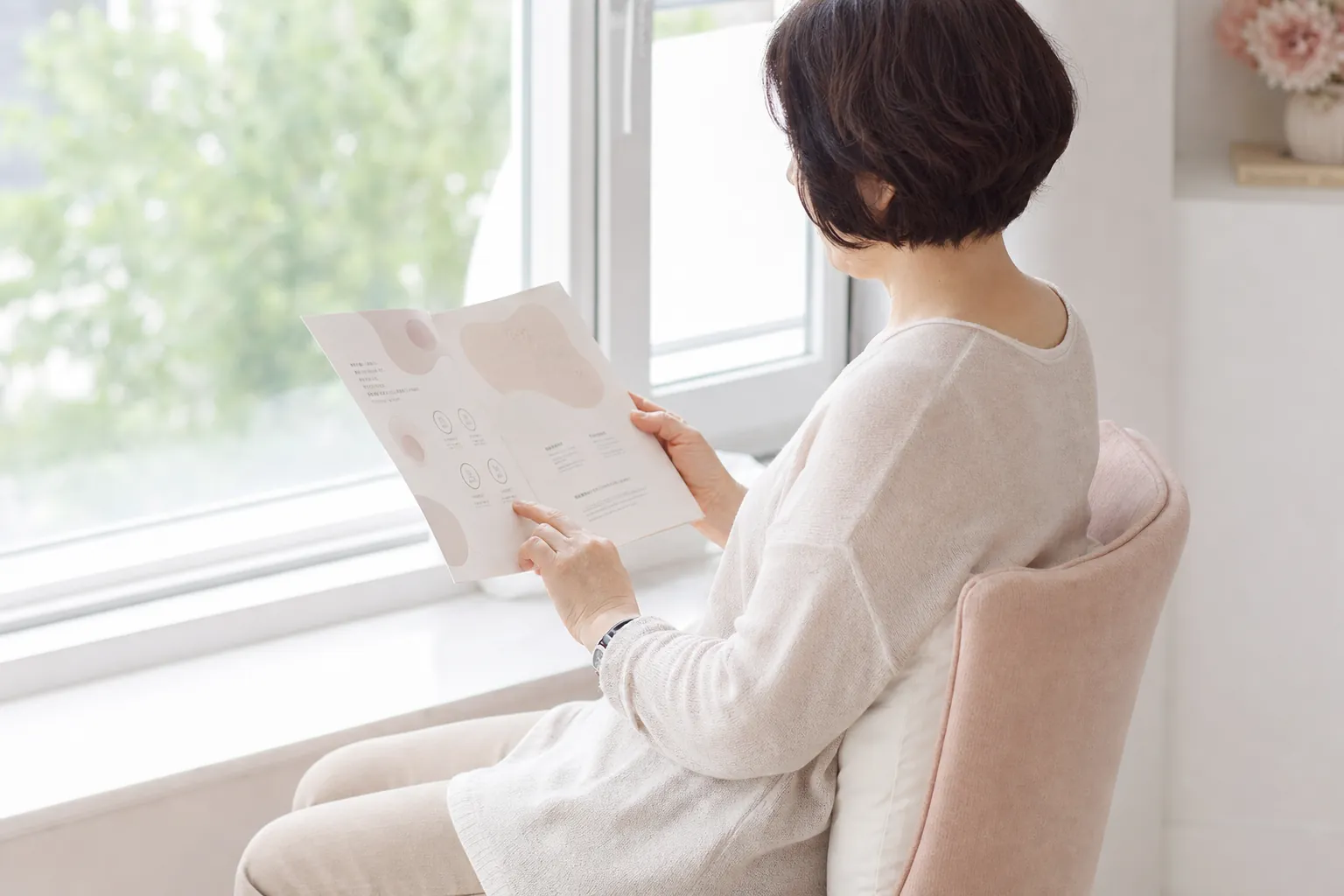밝은 공간에서 안내 자료를 읽는 여성의 옆모습