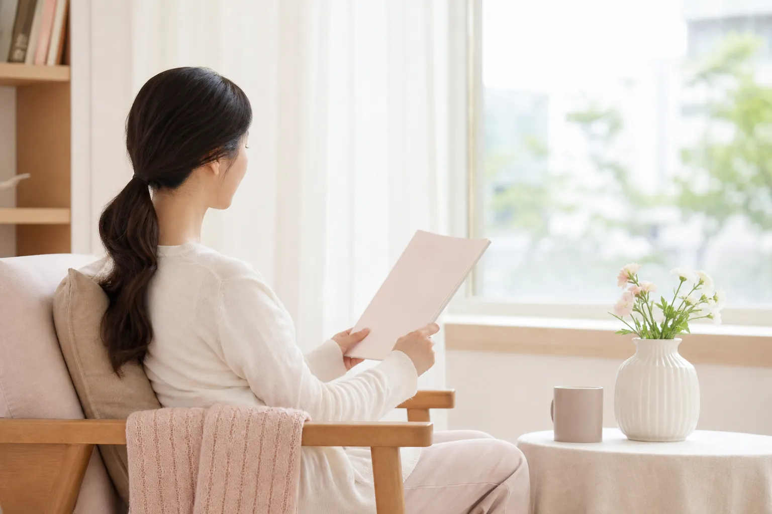 밝은 공간에서 안내 자료를 읽는 여성의 옆모습